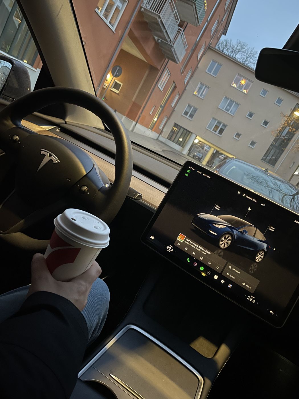 Interior del Tesla de Claudio con un café